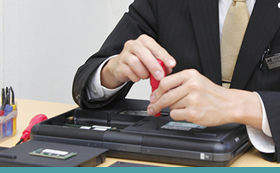 ノートPCを修理するスタッフ